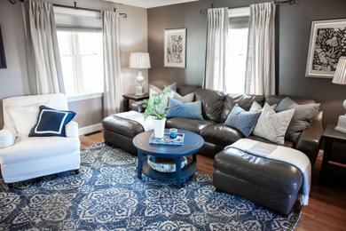 Mid-sized transitional enclosed medium tone wood floor and brown floor family room photo in Boston with blue walls and a wall-mounted tv