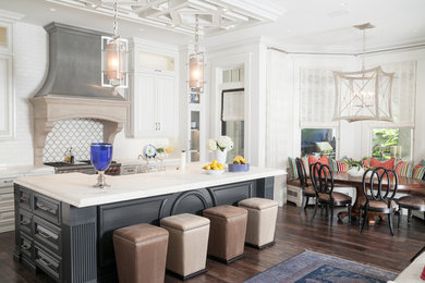 Eat-in kitchen - large contemporary single-wall dark wood floor and brown floor eat-in kitchen idea in Tampa with an undermount sink, raised-panel cabinets, white cabinets, marble countertops, multicolored backsplash, subway tile backsplash, stainless steel appliances and an island