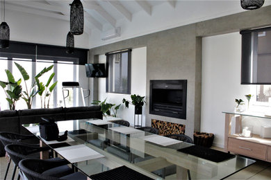 Diseño de sala de estar cerrada industrial con paredes grises, marco de chimenea de piedra y panelado