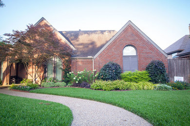 This is an example of a mid-sized traditional full sun front yard formal garden in Dallas.