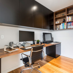 Foto di un ufficio minimal di medie dimensioni con pareti bianche, pavimento in legno massello medio e scrivania incassata