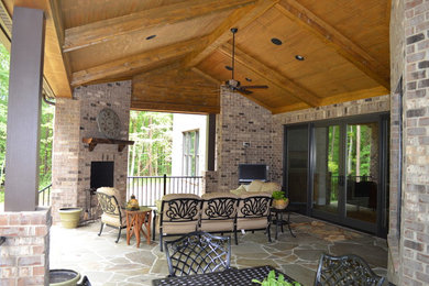 Patio - large backyard stone patio idea in Charlotte with a roof extension