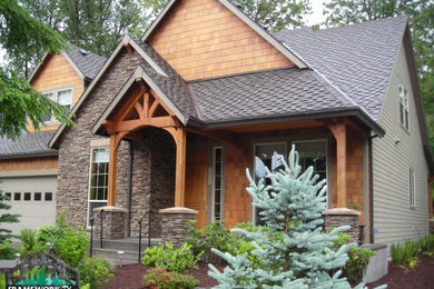 This is an example of a craftsman front porch design in Portland with a roof extension.