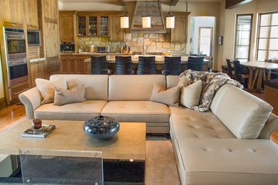 Family room library - mid-sized rustic open concept medium tone wood floor family room library idea in Denver with beige walls, a standard fireplace, a stone fireplace and a wall-mounted tv