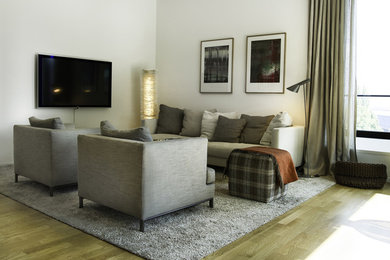 Mittelgroßes, Abgetrenntes Modernes Wohnzimmer ohne Kamin mit weißer Wandfarbe, hellem Holzboden, TV-Wand und braunem Boden in Hamburg