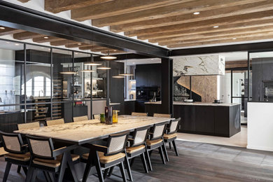Photo of a large industrial open plan dining in Paris with beige walls, dark hardwood floors and black floor.