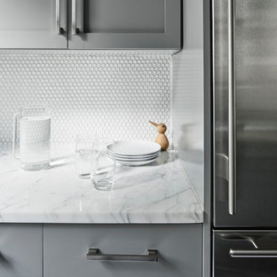 Неиссякаемый источник вдохновения для домашнего уюта: маленькая отдельная, параллельная кухня в стиле модернизм с одинарной раковиной, фасадами в стиле шейкер, серыми фасадами, мраморной столешницей, белым фартуком, фартуком из керамогранитной плитки, техникой из нержавеющей стали, темным паркетным полом и черным полом