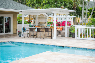 This is an example of a mid-sized traditional backyard l-shaped natural pool in Miami with concrete pavers.