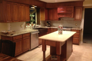 Eat-in kitchen - mid-sized rustic l-shaped travertine floor eat-in kitchen idea in Detroit with a farmhouse sink, raised-panel cabinets, medium tone wood cabinets, limestone countertops, stainless steel appliances and an island