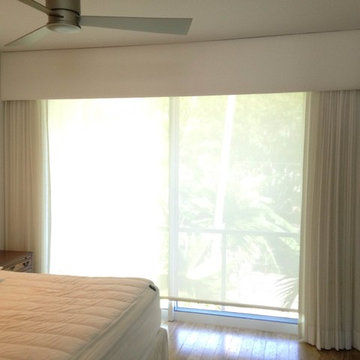 Bedroom with upholstered cornice with traversing sheer drapery