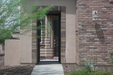 Large southwest brown two-story stone exterior home photo in Phoenix