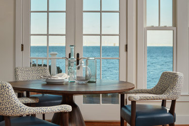 Esempio di una piccola sala da pranzo aperta verso il soggiorno stile marino con pareti bianche, parquet chiaro e pavimento marrone