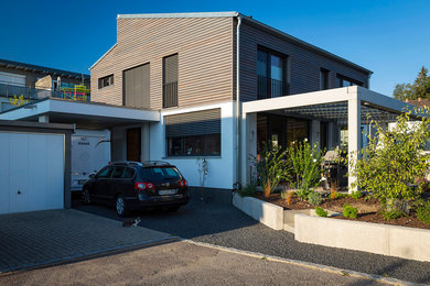 Photo of a large contemporary two-storey grey exterior in Munich with mixed siding and a shed roof.