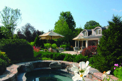 Large backyard custom-shaped natural pool photo in New York