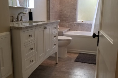 Bathroom - mid-sized transitional beige tile and porcelain tile porcelain tile, beige floor and single-sink bathroom idea in Other with shaker cabinets, white cabinets, a two-piece toilet, beige walls, an undermount sink, quartz countertops, beige countertops and a freestanding vanity