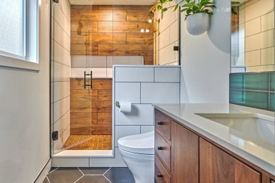 Example of a small danish master multicolored tile and ceramic tile porcelain tile, black floor and single-sink wet room design in Seattle with furniture-like cabinets, medium tone wood cabinets, a bidet, white walls, an undermount sink, quartz countertops, a hinged shower door, white countertops and a freestanding vanity