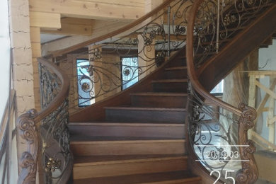 Modelo de escalera curva clásica grande con escalones de madera, contrahuellas de madera y barandilla de madera