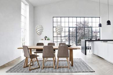 Example of a mid-sized minimalist light wood floor and beige floor great room design in Milwaukee with white walls and no fireplace