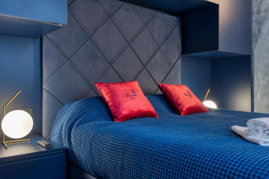 ミラノにある小さなモダンスタイルのおしゃれな客用寝室 (青い壁、無垢フローリング、茶色い床、壁紙、照明) のレイアウト