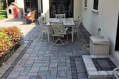 Mid-sized modern backyard patio in Chicago with brick pavers.