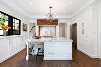 Kitchen - large transitional dark wood floor and brown floor kitchen idea in Bridgeport with an undermount sink, white cabinets, white backsplash, stone slab backsplash, stainless steel appliances, an island, white countertops and shaker cabinets