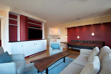 Family room - mid-sized contemporary open concept light wood floor and brown floor family room idea in Other with red walls and a media wall