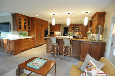 Mid-sized elegant u-shaped porcelain tile eat-in kitchen photo in Newark with a farmhouse sink, beaded inset cabinets, medium tone wood cabinets, granite countertops, multicolored backsplash, mosaic tile backsplash and stainless steel appliances