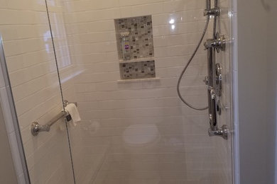 Doorless shower - mid-sized transitional master white tile and ceramic tile ceramic tile and gray floor doorless shower idea in Bridgeport with raised-panel cabinets, white cabinets, a two-piece toilet, gray walls, an undermount sink, granite countertops and a hinged shower door