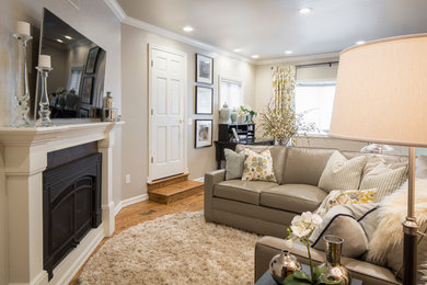 Family room - small modern enclosed medium tone wood floor family room idea in Phoenix with gray walls, a standard fireplace and a wall-mounted tv