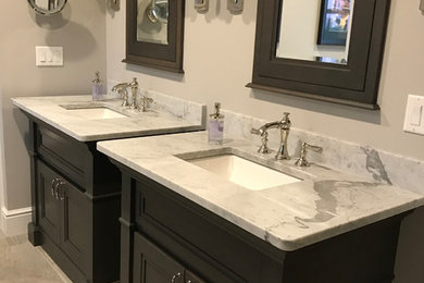 Small traditional master bathroom in Bridgeport with recessed-panel cabinets, dark wood cabinets, grey walls, porcelain floors, an undermount sink, granite benchtops and beige floor.