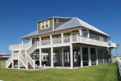 Идея дизайна: двухэтажный, серый частный загородный дом среднего размера в морском стиле с облицовкой из винила и металлической крышей