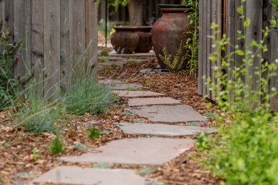 This is an example of a mid-sized transitional side yard stone and wood fence garden path in Sacramento.