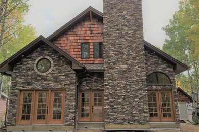 Mountain style two-story stone gable roof photo in Other