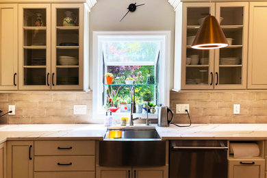 This is an example of a large transitional u-shaped open plan kitchen in DC Metro with a farmhouse sink, recessed-panel cabinets, white cabinets, quartz benchtops, beige splashback, ceramic splashback, stainless steel appliances, light hardwood floors, with island, beige floor and white benchtop.