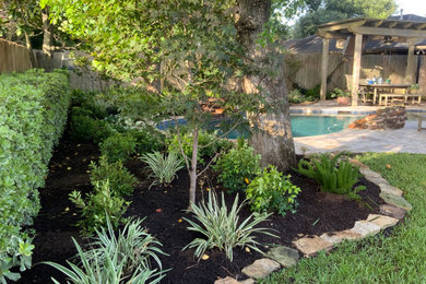 Imagen de jardín clásico renovado de tamaño medio en verano en patio trasero con jardín francés, parterre de flores, exposición reducida al sol y gravilla
