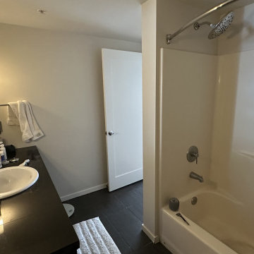 Large-Format Marble Shower & Dark Vanity Bathroom
