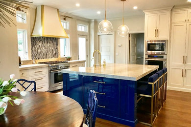 This is an example of a large contemporary u-shaped eat-in kitchen in New York with flat-panel cabinets, white cabinets, quartzite benchtops, blue splashback, glass tile splashback, stainless steel appliances and with island.