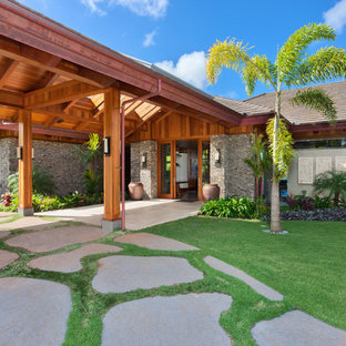 ハワイのトロピカルスタイルのおしゃれな家の外観 (グレーの外壁、戸建、コンクリートサイディング、半切妻屋根、板屋根) の写真