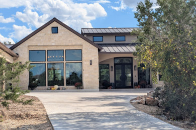 Inspiration for a large cottage beige one-story stucco house exterior remodel in Austin with a shed roof, a metal roof and a brown roof