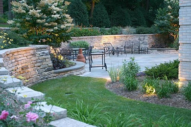 Photo of a mid-sized traditional backyard partial sun garden for summer in Milwaukee with brick pavers.