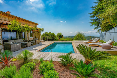 Diseño de piscina natural contemporánea de tamaño medio rectangular en patio lateral con paisajismo de piscina y entablado