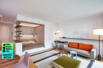 Modelo de dormitorio principal y gris y blanco contemporáneo pequeño con paredes blancas y suelo de madera clara