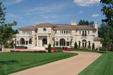 Inspiration for a huge mediterranean two-story stucco exterior home remodel in Denver with a hip roof, a tile roof and a brown roof