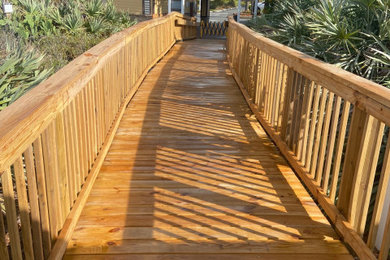 Large island style backyard wood railing deck photo in Orlando with a pergola