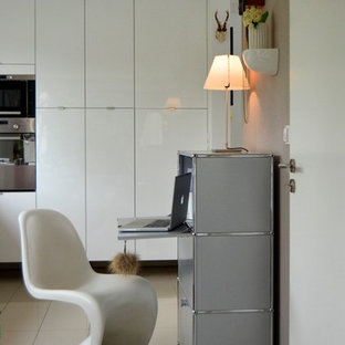 Exempel på ett litet modernt hemmabibliotek, med klinkergolv i keramik, ett fristående skrivbord och beige väggar