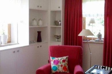 Großes, Offenes Klassisches Wohnzimmer mit weißer Wandfarbe, hellem Holzboden, Kaminofen, verputzter Kaminumrandung, verstecktem TV und braunem Boden in Sonstige