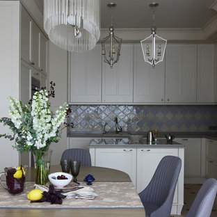 На фото: с высоким бюджетом п-образные, отдельные кухни среднего размера в стиле современная классика с белыми фасадами, серым фартуком, островом и фасадами с утопленной филенкой