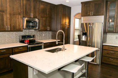 Eat-in kitchen - modern l-shaped dark wood floor eat-in kitchen idea in Denver with an undermount sink, shaker cabinets, dark wood cabinets, quartz countertops, metallic backsplash, glass tile backsplash, stainless steel appliances and an island