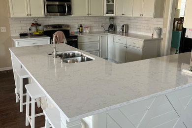 Example of a mid-sized minimalist eat-in kitchen design in Indianapolis with shaker cabinets, white cabinets, quartz countertops, white backsplash and white countertops