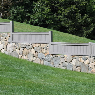 Photo of a large traditional backyard full sun garden in New York with a retaining wall.